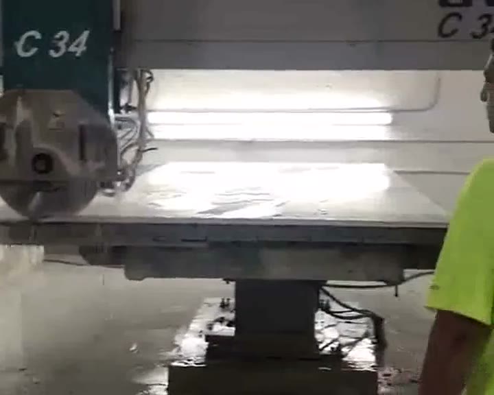 C 34 bridge saw cutting a stone slab with water spray on the Versa Stone fabrication floor