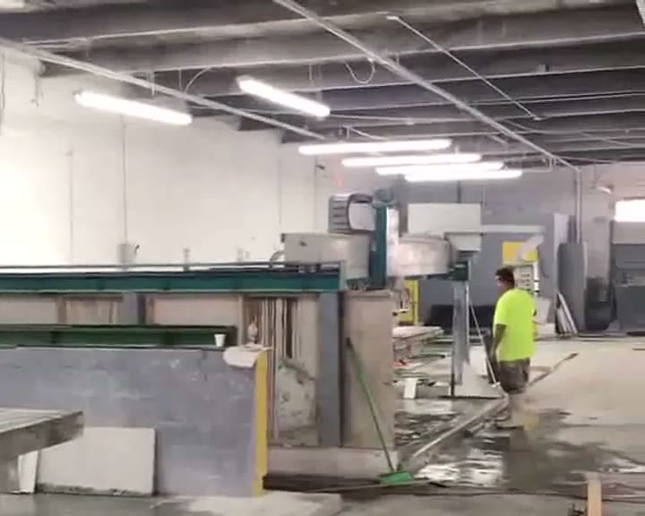 Versa Stone Lauderhill production floor showing CNC bridge saws and a production worker on the active shop floor