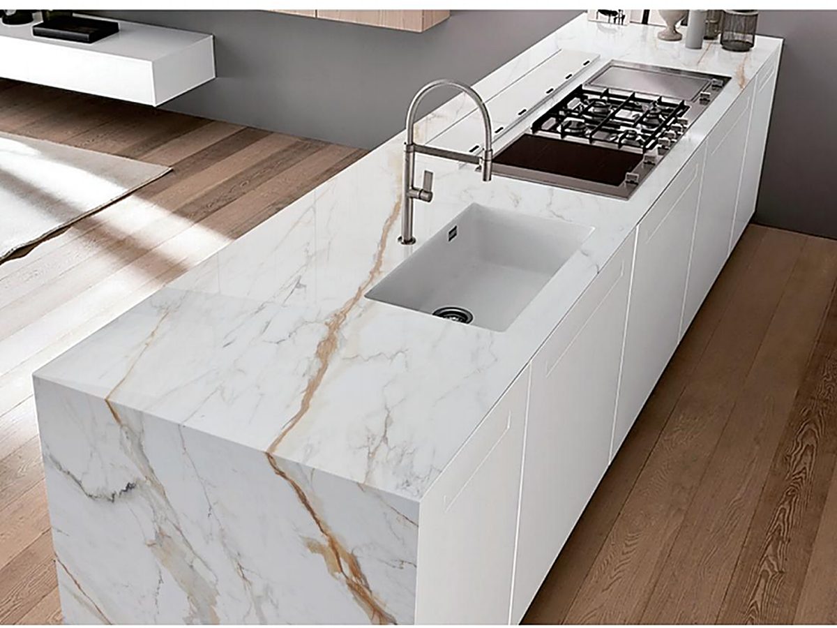 Long quartz kitchen island with waterfall edges in white and gold veined slab